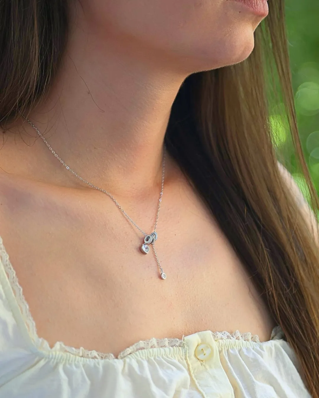 Srebrna ogrlica Diamond Glow White Heart sa kristalnim srcem na modelu u beloj čipkanoj bluzi