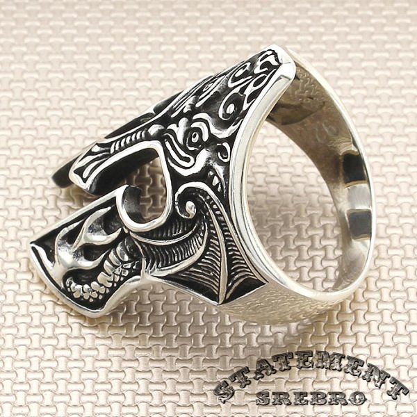 Muški prsten oblika ratničkog šlema od 925 Srebra sa motivima zmaja. Na prvi pogled, oduševiće oblikom, kada se udubite, oduševiće detaljima.