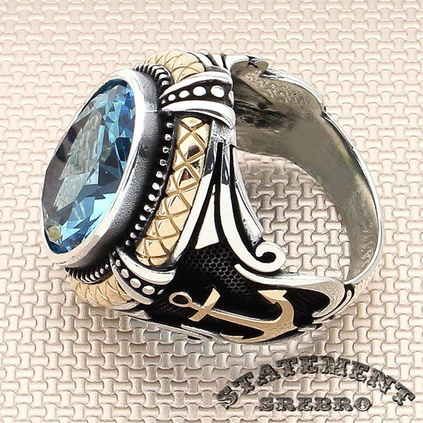Muški prsten masivnog akvamarin kamena i 925 Srebra sa motivima sidra, na ovom prstenu, odavaće morski utisak.