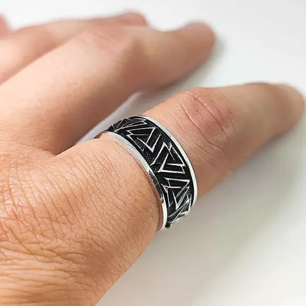 Srebrni muski prsten oblika burme, crne boje sa isprepletanim trouglovima.