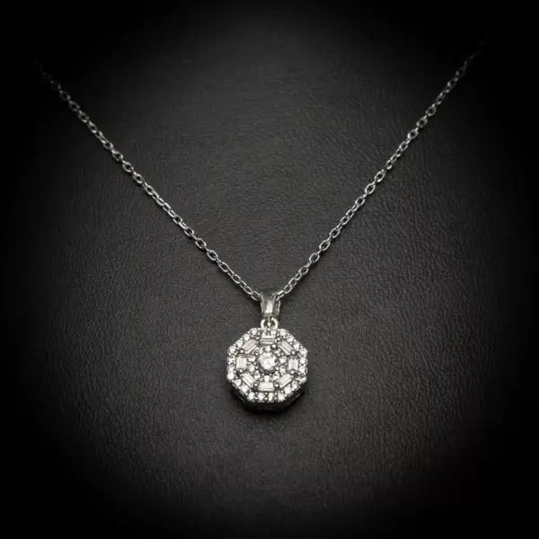 Ova prefinjena ogrlica od 925 srebra ima osmougaoni privezak koji blista zahvaljujući besprekorno postavljenim cirkonima. Svaki ugao ovog oktagona sjaji poput dijamanata, čineći je izuzetno elegantnom i privlačnom.