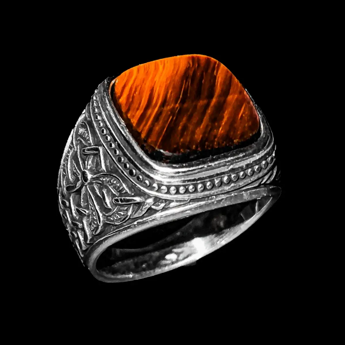 Izrađen sa izvanrednom pažnjom, ovaj srebrni muški prsten odiše elegancijom i sofisticiranošću. Sa svojim prefinjenim dizajnom, ovaj prsten ima simbol isprepletanog veza na strani, predstavljajući snagu i dubinu povezanosti. U središtu prstena nalazi se četvrtasti kamen tigrovo oko, koji pruža suptilnu toplinu i privlačnost. Jedinstvena kombinacija simbola i Tigrovog oka čini prsten savršenim izborom za elegantne i stilski osvešćene muškarce.