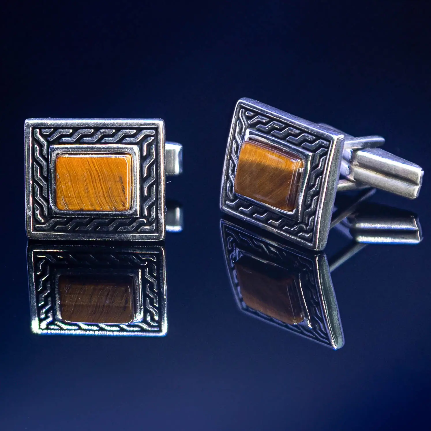 Srebrne manžetne sa kamenom Tigrovo oko na beloj pozadini – luksuzan i prirodan detalj muške elegancije.