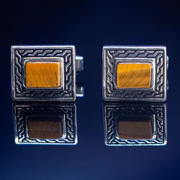 Srebrne manžetne sa kamenom Tigrovo oko na beloj pozadini – luksuzan i prirodan detalj muške elegancije.